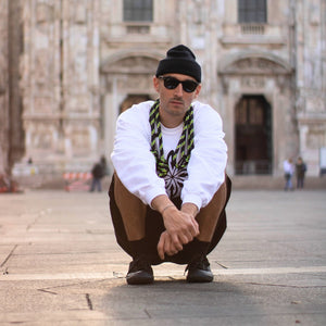 Good Flow in front of Milan's cathedral with a black cap, a pair of sunglasses, a white jumper and his Court SP rope