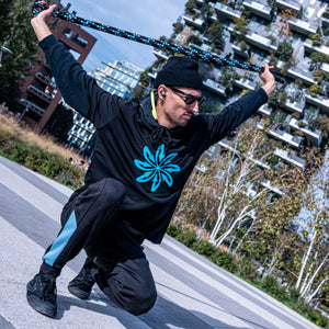Phil wearing his black t-shirt with blue logo and holding his Good Flow Milano Australiana rope above his head, with Milan's Bosco Verticale in the background.